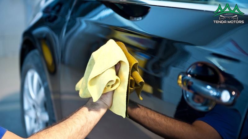 Secagem de carro preto com toalha de microfibra